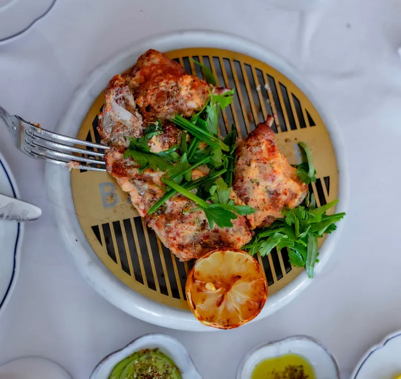 Poulet grillé avec citron et herbes sur une assiette. Photographie d’inspiration.